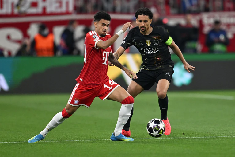 Bayern-Stürmer Diáz und PSG-Kapitän Marquinhos kämpfen um den Ball. — © Sven Hoppe/dpa