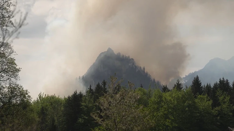 Dichter Rauch ist über dem Berg in den bayerischen Alpen zu sehen. — © Gabriel Neumayr/dpa